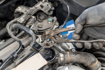 Hand with tool, fixing nut in car engine, close up