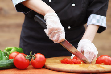 The cook cuts fresh farm vegetables