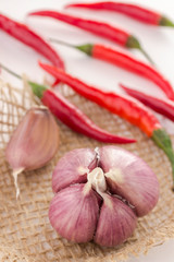 Red chili peppers and garlic cloves on a white background. Top view.