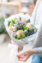 beautiful fresh cut bouquet of mixed flowers in woman hand. the work of the florist at a flower shop.