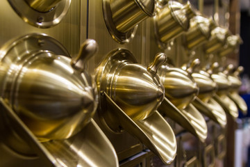 Close-up photo with selective focus of brass coffee bean dispensers in a Russian coffee shop