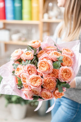beautiful fresh cut bouquet of mixed flowers in woman hand. the work of the florist at a flower shop