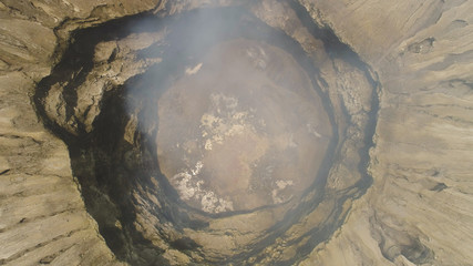 Fototapeta premium smoking crater active volcano Bromo. aerial view mountain landscape volcano crater and mountains Tengger Semeru national park Java, Indonesia.