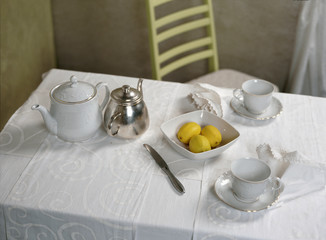 tableware with lemons, cup, sugar bowl and knife