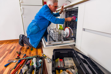 Service man fixing dishwasher machine