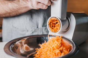 Chopping carrots into a fine grater using an electric food processor