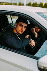 Thieves parked in an ally waiting while observing their target and loading their guns.