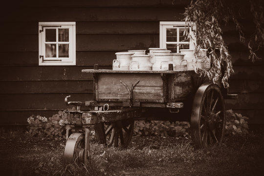 old traditional Dutch cans in a carriage in village. Holland, Netherlands . Image in sepia color style