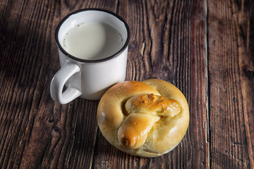 Rustic style.Butter bun and a glass of milk on a wooden table.