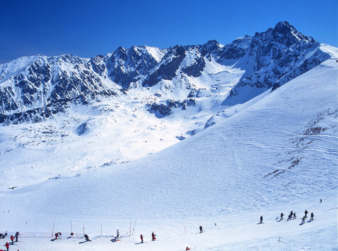 Tatry, Poland - February, 2008: skiers on Kasprowy Wierch and view to Swinica peak