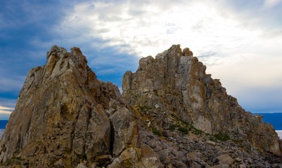 Landscape with landmark a Shamanka Rock on Olkhon Island near Khuzhir on Baikal lake in dusk. Summer vacation in the heart of Siberia. The sacred place of Buddhists and shamans