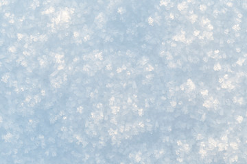 Macrophoto of fresh snowflakes and snow on the ground on a sunny day, good as a winter season background or texture.