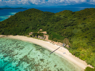 Fototapeta premium Aerial view of tropical island Bulalacao. Beautiful tropical island with white sandy beach, palm trees and green hills. Travel tropical concept. Palawan, Philippines