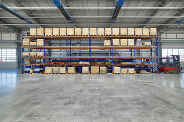Large, spacious assembly shop. High storage racks with wooden boxes