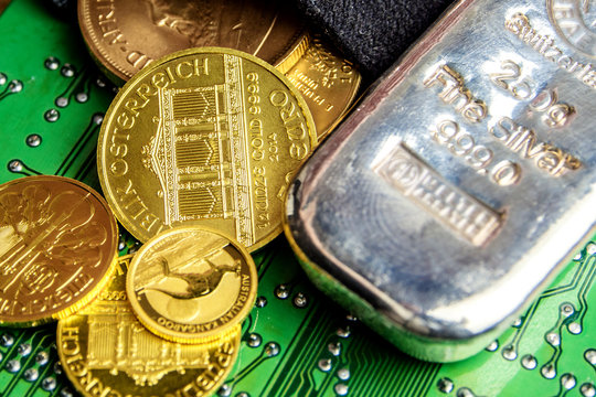 golden coins and silver brick laying on green circuit board electronic hardware technology