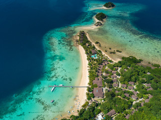 Aerial view of tropical island Bulalacao. Beautiful tropical island with white sandy beach, palm trees and green hills. Travel tropical concept. Palawan, Philippines