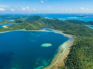 Obraz premium Aerial view of tropical island Bulalacao. Beautiful tropical island with white sandy beach, palm trees and green hills. Travel tropical concept. Palawan, Philippines