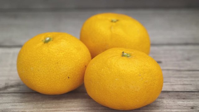 Close up 4k establishing shot of orange fruit on wooden table