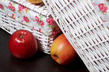 Apples on the table. Next to white wicker baskets.