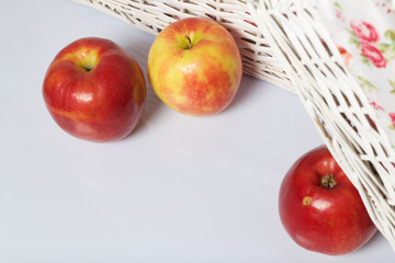 Apples on the table. Next to white wicker baskets.