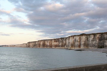 the beautiful white alabaster cliff coast with high tide and a cloudy sky in normandy