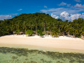 Aerial view of tropical  beach of island Bulalacao. Beautiful tropical island with white sandy beach, palm trees and green hills. Travel tropical concept. Palawan, Philippines