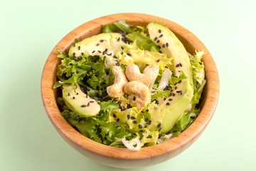 Fototapeta na wymiar Tasty salad with frisee, avocado, cashew nuts and black sesame