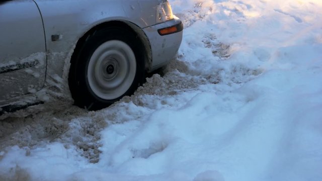 Car stuck in snow. Wheel of car is stuck in snow. Driving and bad winter weather conditions.