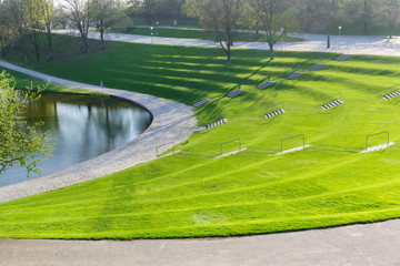 Obraz premium Spring city park with green terrace lawn and staircase