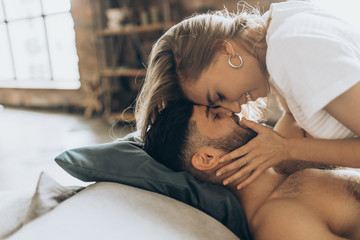 beautiful loving couple kissing in bed