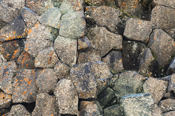Textured basalt background hexagonal stone pillars in a section. natural volcanic formations