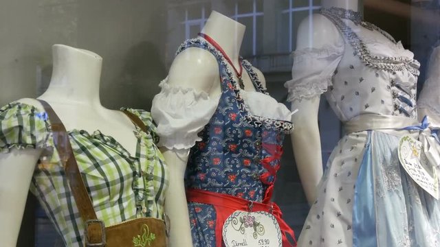 Beautiful various women's national Bavarian costumes dirndl on shop window