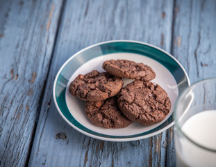 A plate of chocolate cookies on blue wooden floor