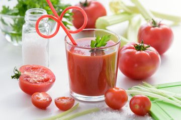 Most useful juice. Tomato juice in glass with celery, cherry tomato, white wood background, closeup