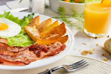 Fried bacon. Delicious golden crusty crust of French fries in a fast food cafe. Unhealthy, but tasty unhealthy food. Fried potato sticks with bacon and egg.