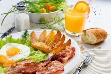 Delicious golden crusty crust of French fries in a fast food cafe. Unhealthy, but tasty unhealthy food. Fried potato sticks with bacon and egg.