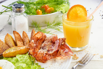 Delicious golden crusty crust of French fries in a fast food cafe. Unhealthy, but tasty unhealthy food. Fried potato sticks with bacon and egg.