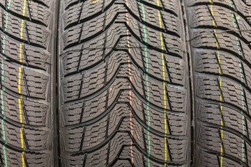new tires for sale at booth in store. Winter Season Tire Tread. Brand New Car Tires on the Shelf.