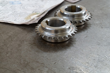 Two gears lie on a testing table with technical drawings.