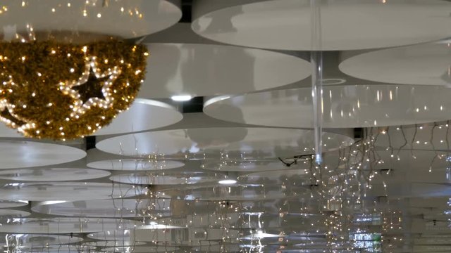 Reflection on the ceiling christmas decorated pedestrian underpass in which people are in a hurry, Karlsplatz, Stachus, Munich.
