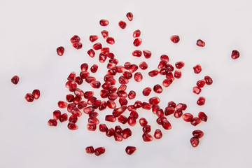 Close-up of pomegranate seeds texture on a white background, top view.  Ripe red garnet fruit 