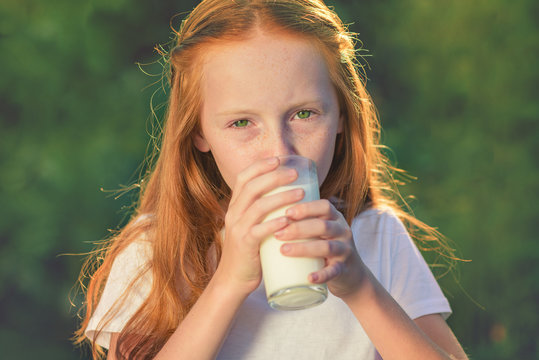 Drink milk. Healthy baby milk - Portrait of a lovely girl drinking fresh  milk outdoors. Drinking milk is good for health. Stock Photo | Adobe Stock