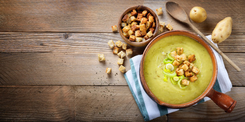 Leek and potato soup with croutons. Top view, space for text