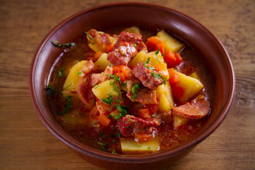 Delisious homemade stew. Goulash soup in a bowl on wooden table. horizontal.