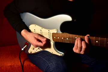 Naklejka premium Man playing a electric guitar. Closeup, no face.