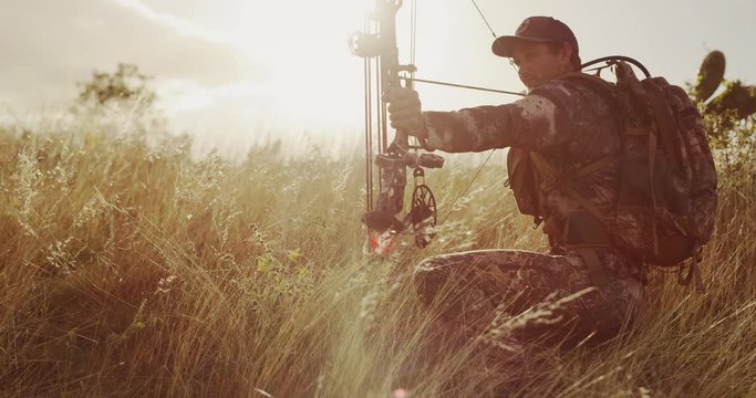 Orbit shot of bowhunter drawing an arrow in his compound bow