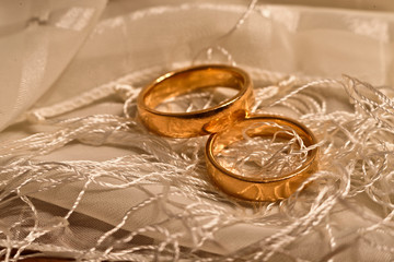 Wedding rings lying together on a white scarf