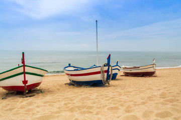 Naklejka na ściany i meble Wooden fishing boat on a sandy beach in sunny day. Place for text