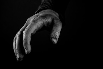 Helping hands concept, Man's hands reaching out, asking for help, close up, black and white