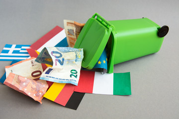 flags of the countries of the European Union, euro banknotes in the garbage can. concept of crisis 